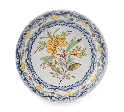 Lot 26 - An English Delft Plate, mid 18th century, painted in colours with a central flowerspray within...