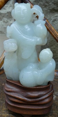 Lot 117 - A Chinese Jade Figure Group, as a figure standing holding a vase of flowers, a child with a...