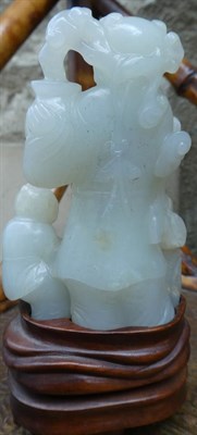 Lot 117 - A Chinese Jade Figure Group, as a figure standing holding a vase of flowers, a child with a...