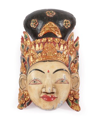 Lot 120 - A South East Asian Carved, Painted and Gilt Mask, with extensive leaf and scroll carved headdress