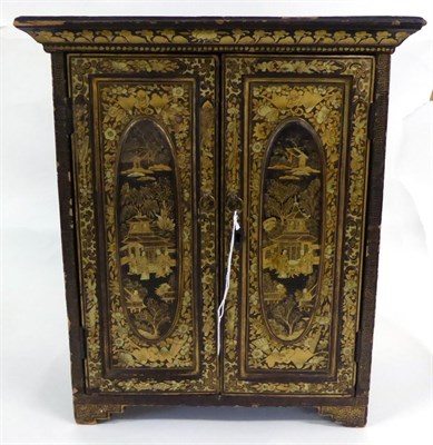 Lot 121 - A Chinese Export Lacquered Table Cabinet, mid 19th century, with two panelled doors with figures in