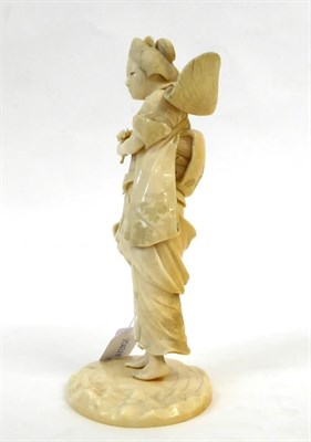 Lot 128 - A Japanese Ivory Okimono as a Girl, Meiji period, in traditional dress holding a sickle and posy on