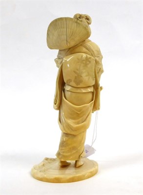 Lot 128 - A Japanese Ivory Okimono as a Girl, Meiji period, in traditional dress holding a sickle and posy on