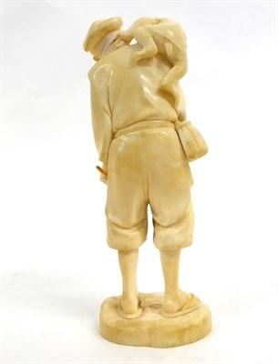 Lot 133 - A Japanese Ivory Okimono as a Farmer, Meiji period, standing holding a bunch of vegetables and...