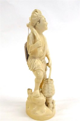 Lot 136 - A Japanese Ivory Okimono as a Fisherman, Meiji period, standing holding a net, a pole and a basket