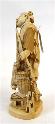 Lot 139 - A Japanese Ivory Okimono as a Fisherman, Meiji period, standing holding a rod, basket and umbrella
