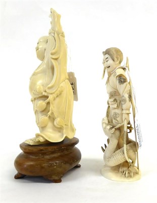 Lot 145 - A Japanese Ivory Okimono as a Samurai, Meiji period, standing holding a knife, a dragon at his...