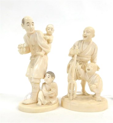 Lot 152 - A Japanese Ivory Okimono as a Father, Meiji period, carrying a child on his back, a further...
