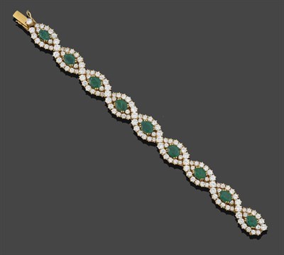 Lot 219 - An Emerald and Diamond Bracelet, articulated links each set with an oval cut emerald within a...