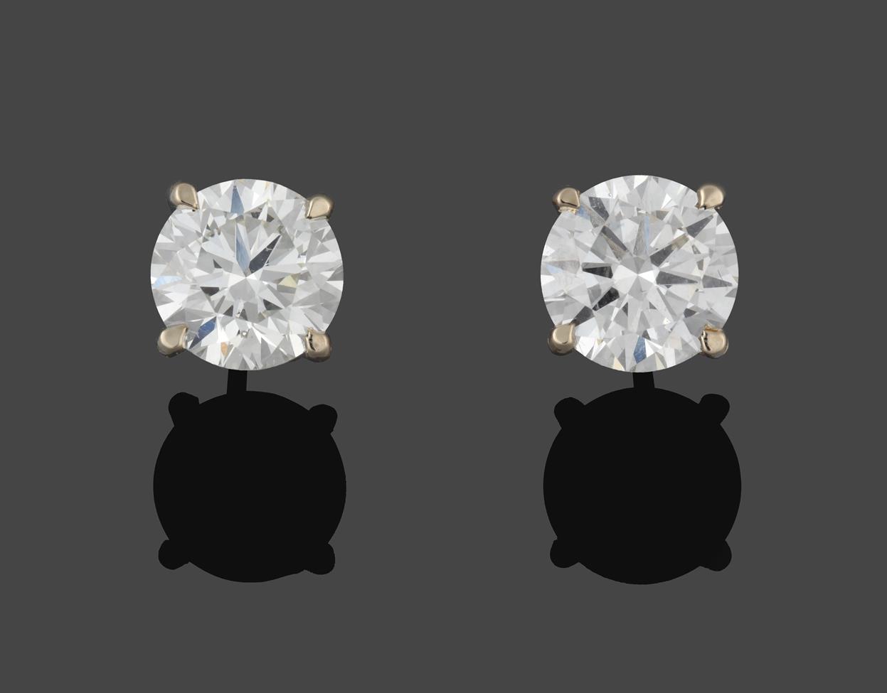 Lot 224 - A Pair of 18 Carat White Gold Diamond Solitaire Earrings, the round brilliant cut diamonds in...