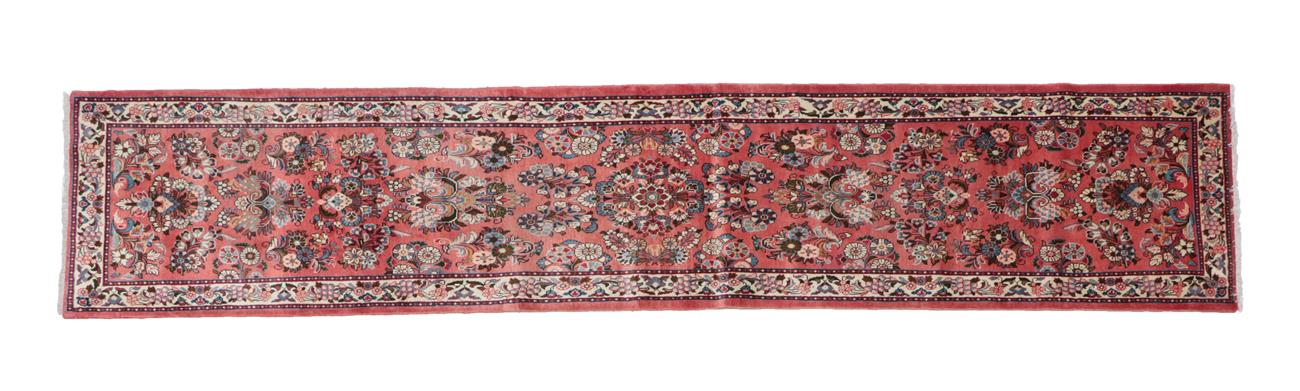 Lot 502 - Narrow Saroukh Runner West Iran, circa 1980 The coral pink field with columns of...