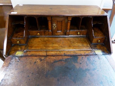 Lot 570 - An Early 18th Century Oak Bureau, the crossbanded fall enclosing a fitted interior of pigeon holes