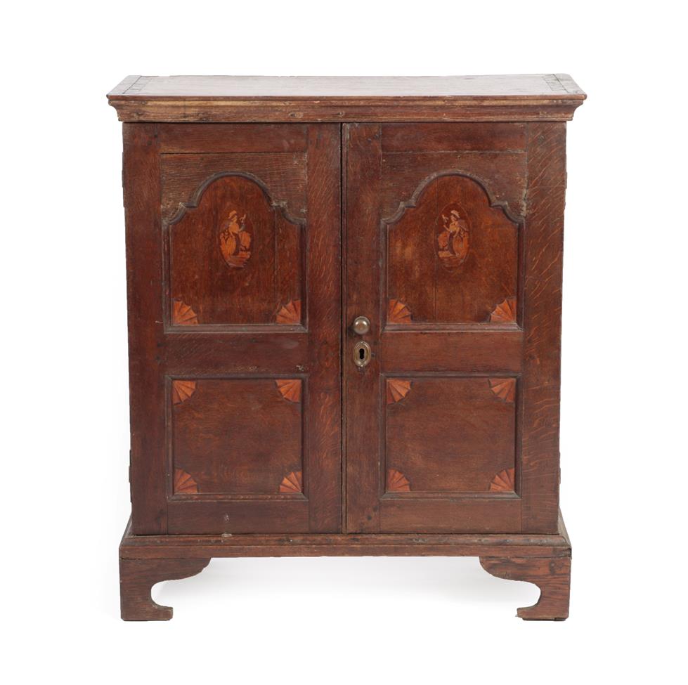 Lot 578 - A Mid 18th Century Oak Cupboard, the moulded cornice above arched cupboard doors with four...