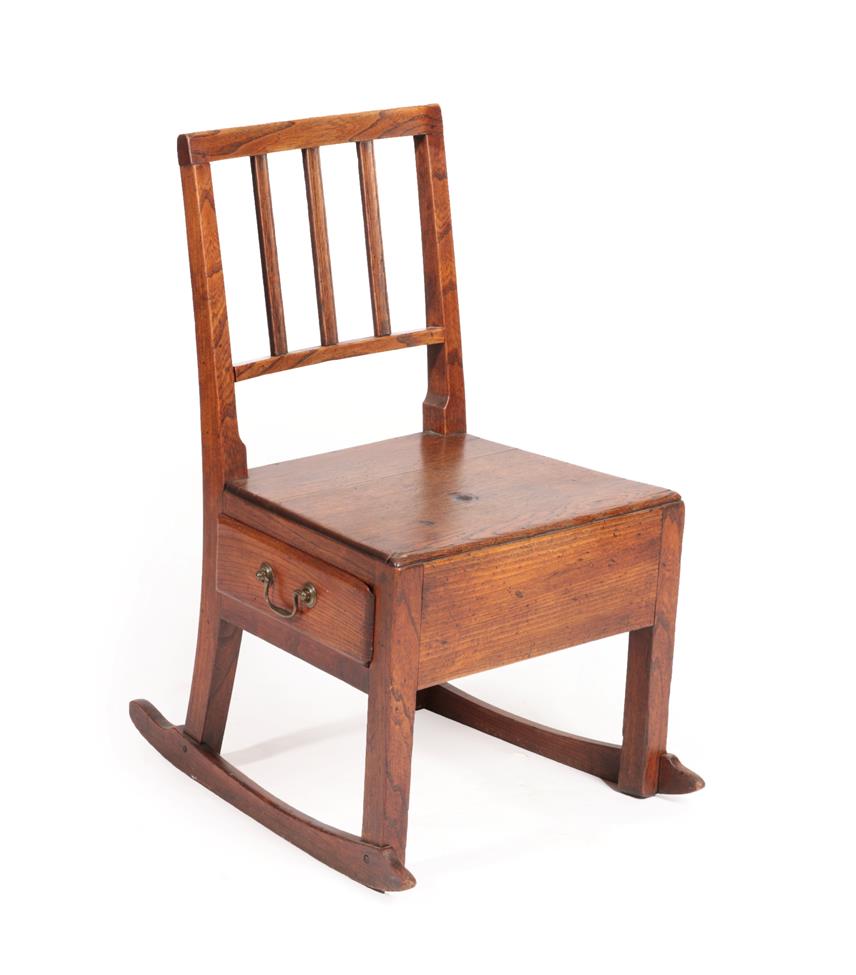 Lot 580 - A George III Oak Lambing/Rocking Chair, early 19th century, the spindle back above a solid seat and