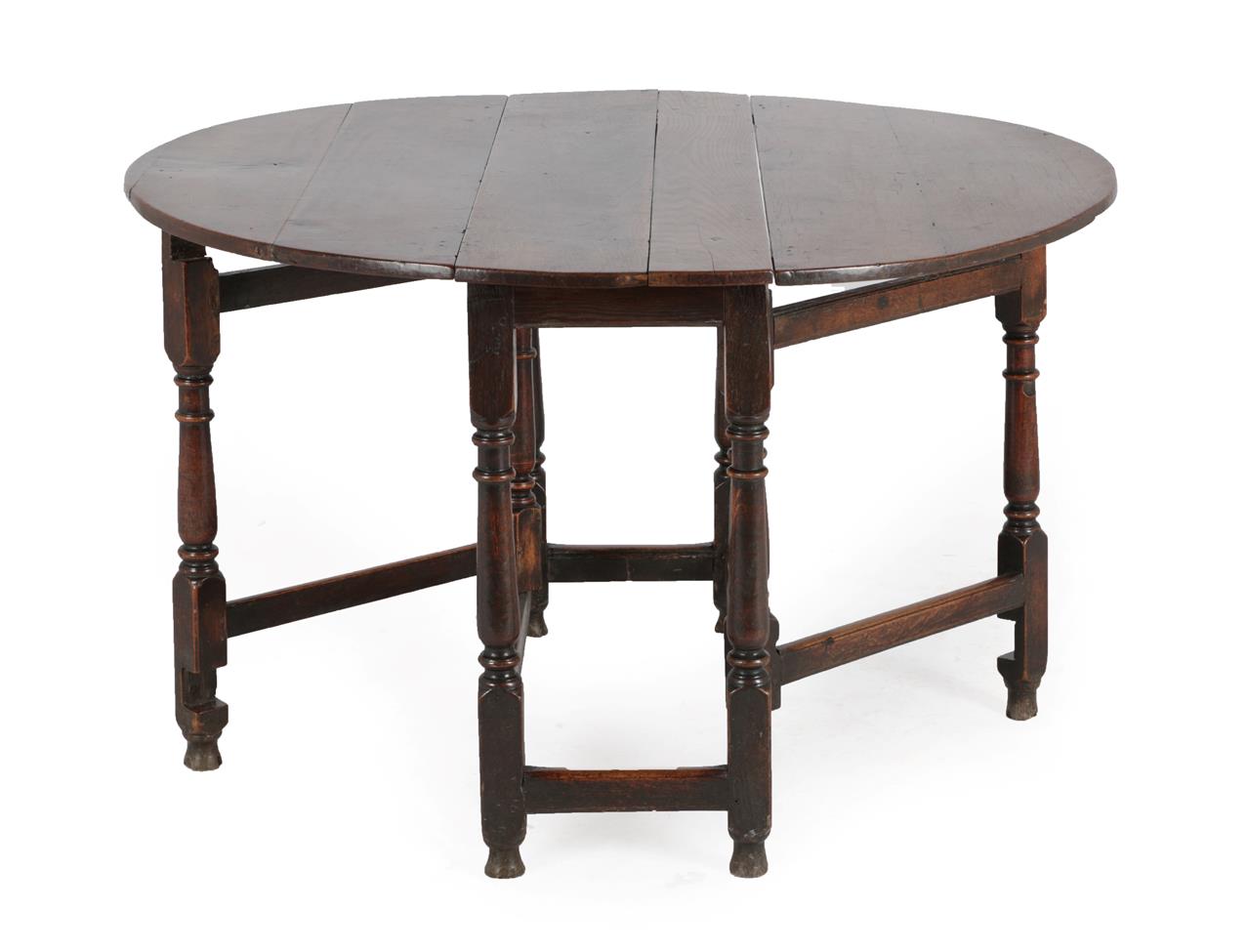 Lot 587 - An Early 18th Century Oak Six-Seater Gateleg Table, with two drop leaves to form an oval, on...