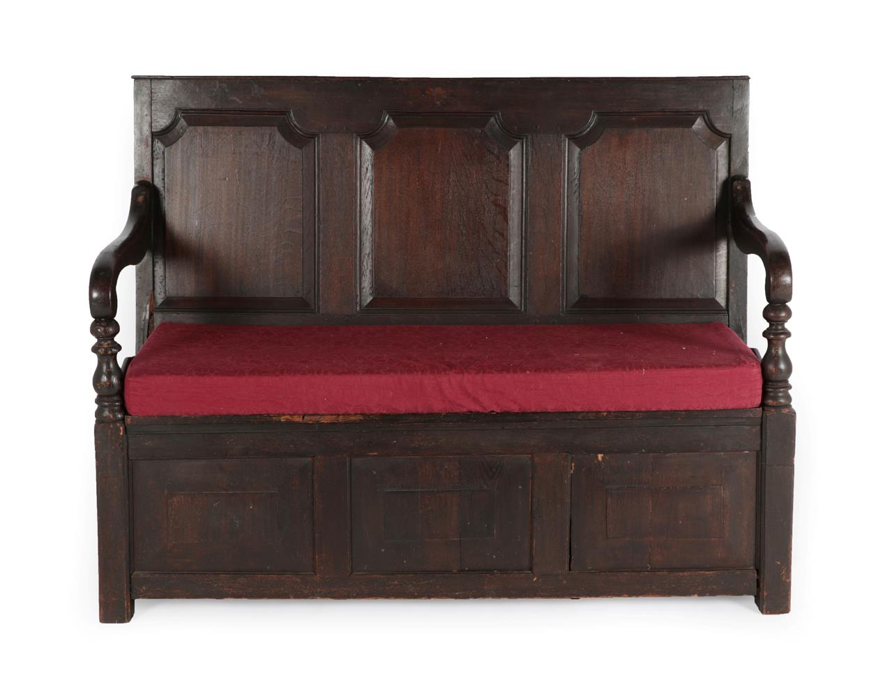 Lot 590 - A Joined Oak Settle, with three fielded panels above downswept arms with bobbin turned...