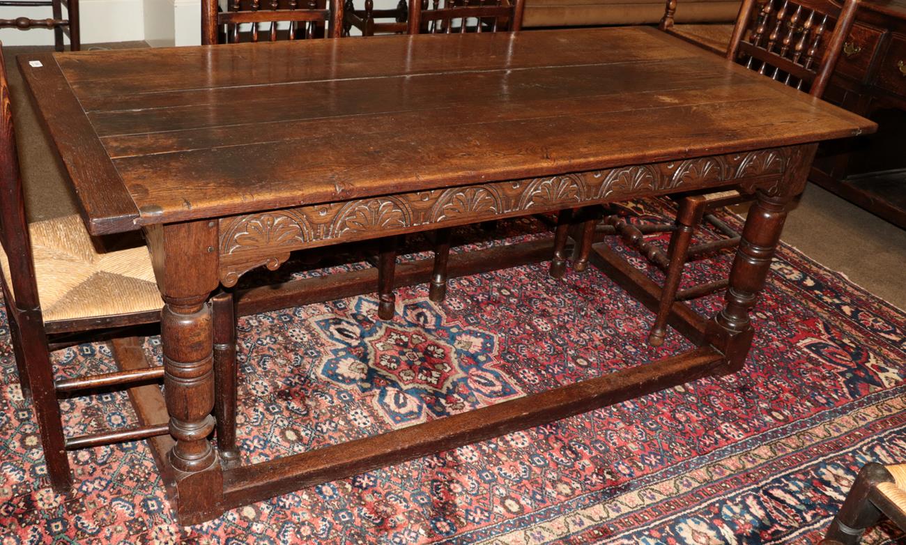 Lot 596 - A Joined Oak Refectory Dining Table, in 17th century style, the plank top with cleated ends above a