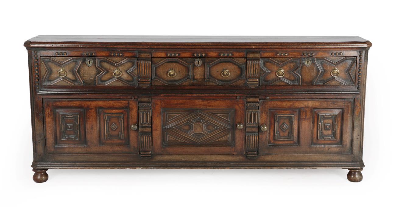 Lot 600 - A Late 17th/Early 18th Century Enclosed Oak Dresser, the crossbanded top above three geometric...