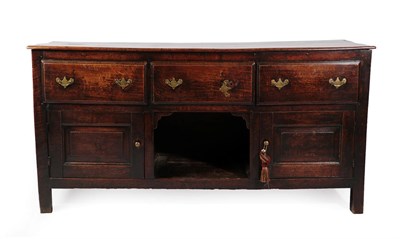 Lot 615 - A Mid 18th Century Oak Enclosed Low Dresser, with three deep drawers above an open shelf flanked by