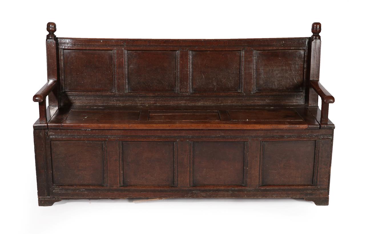 Lot 636 - An 18th Century Joined Oak Settle, the back support with turned finials above four fielded and...