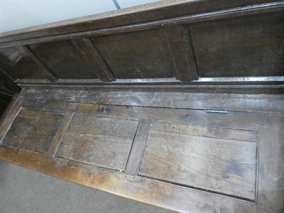 Lot 636 - An 18th Century Joined Oak Settle, the back support with turned finials above four fielded and...