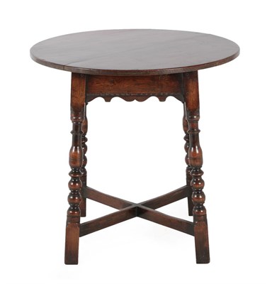 Lot 720 - A Circular Oak Pub or Occasional Table, 20th century, with wavy shaped apron, on baluster and...