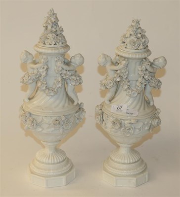 Lot 67 - A pair of Meissen style porcelain urns and covers decorated with putti and flowers