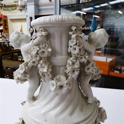 Lot 67 - A pair of Meissen style porcelain urns and covers decorated with putti and flowers