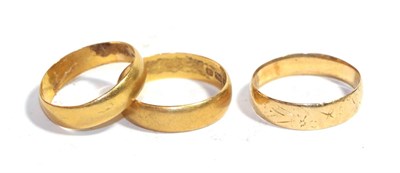 Lot 253 - An 18 carat gold textured band ring, finger size P; and two 22 carat gold band rings, finger...