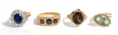 Lot 259 - Four 9 carat gold gem set rings including a garnet example, an opal and emerald example etc,...