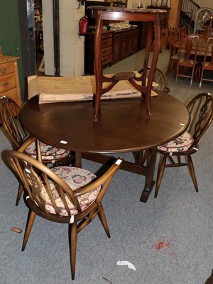 Lot 1131 - An Ercol dark elm dining suite, comprising table, four chairs (including two carvers) and sideboard