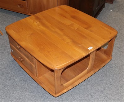 Lot 1136 - An Ercol light elm coffee table, fitted with drawers and recesses, moving on castors, 40cm by...
