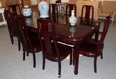 Lot 1165 - A large Chinese hardwood dining table and ten chairs including two carvers, 76cm by 244cm by 112cm