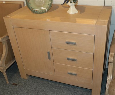 Lot 1172 - A modern limed oak cabinet fitted with three short drawers next to a cupboard door, 90cm high...