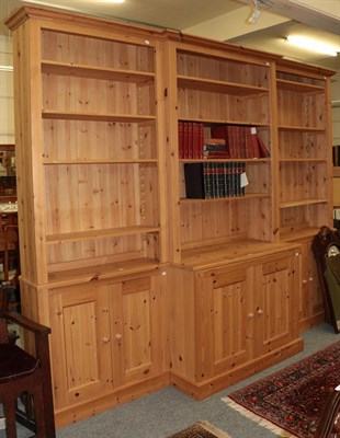 Lot 1184 - An impressive pine break front triple bookcase, 245cm high by 310cm wide by 57cm deep