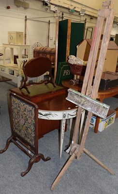 Lot 1193 - A mahogany and cream painted demi-lune side table, a carved firescreen and a folding easel (3)