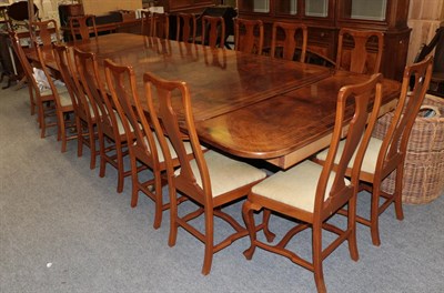 Lot 1208 - A reproduction inlaid walnut twin pillar extending dining table, together with a matching set...