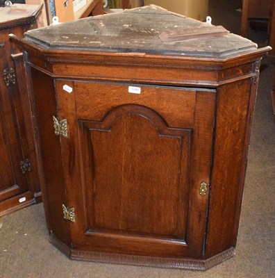 Lot 1240 - A George the III panelled oak hanging corner cupboard, 92cm by 85cm by 51cm