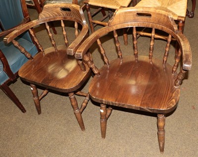 Lot 1298 - A pair of 20th century oak captains' chairs; and a music cabinet (3)