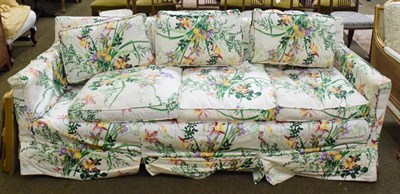 Lot 1306 - A three seated sofa, upholstered in floral fabric