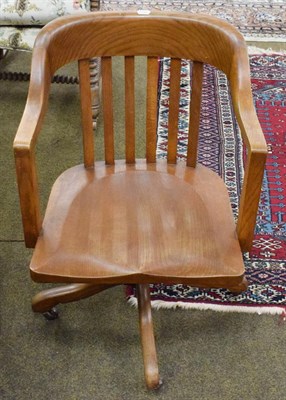 Lot 1311 - An early 20th century oak swiveling office chair