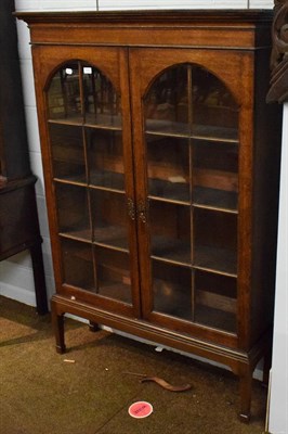 Lot 1331 - An oak glazed two door bookcase on stand, raised on square section tapering legs