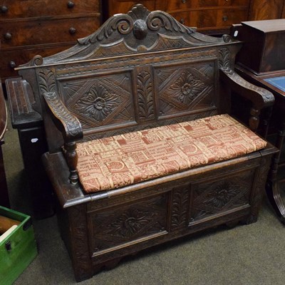 Lot 1341 - A carved oak boxed settle