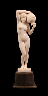 Lot 2027 - An Art Nouveau Carved Ivory Figure, circa 1910, of a nude maiden carrying a water urn, on a...