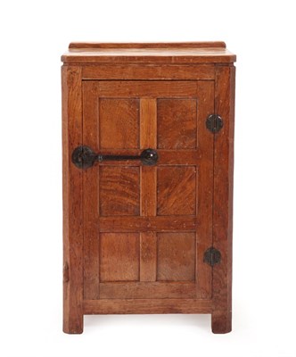 Lot 2040 - Robert Mouseman Thompson (1876-1955): An English Oak Panelled Bedside Cupboard, 1930's, with raised