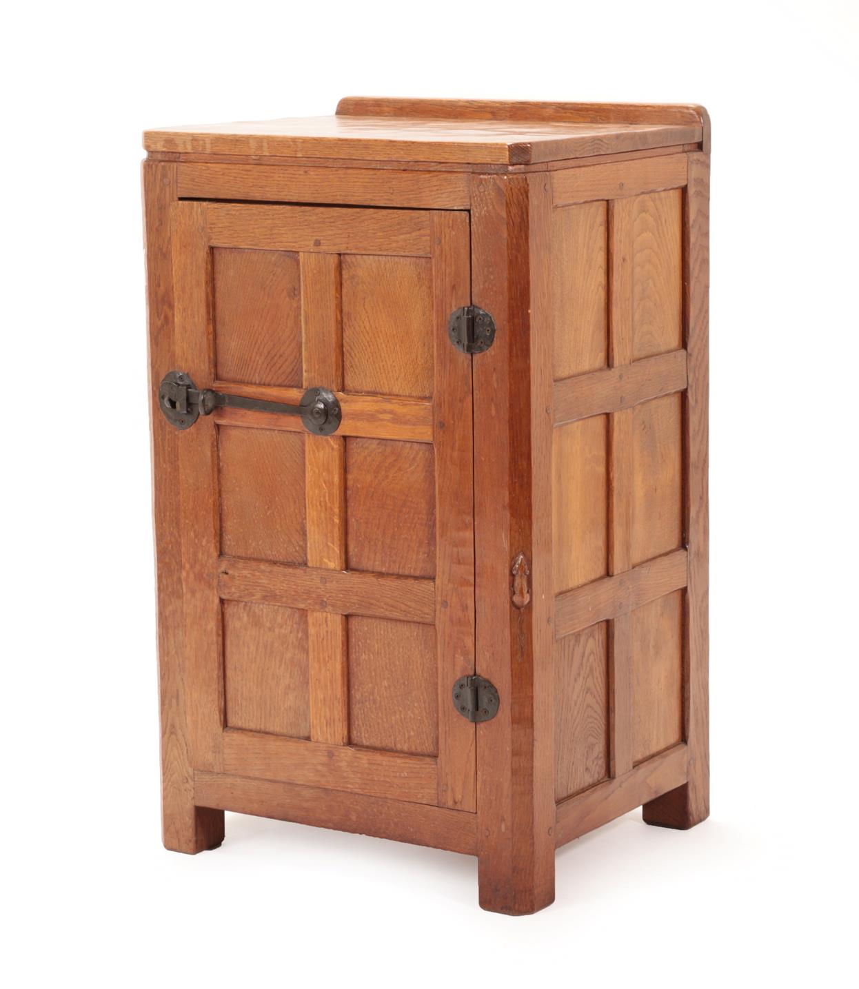 Lot 2041 - Robert Mouseman Thompson (1876-1955): An English Oak Panelled Bedside Cupboard, 1930's, with raised