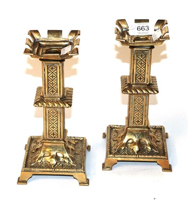 Lot 663 - A pair of 19th century brass candlesticks with castellated tops