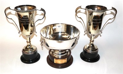 Lot 682 - Two twin handled silver plated trophy cups, and a silver plated trophy bowl with ring and lion mask