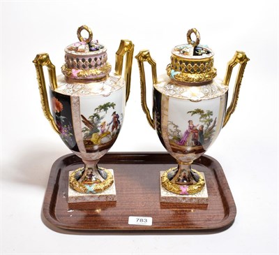 Lot 783 - A pair of German porcelain urns and covers decorated with courting couples