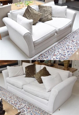 Lot 1118 - A modern cream three-seater sofa, and matching two-seater sofa with scatter cushions, retailed...